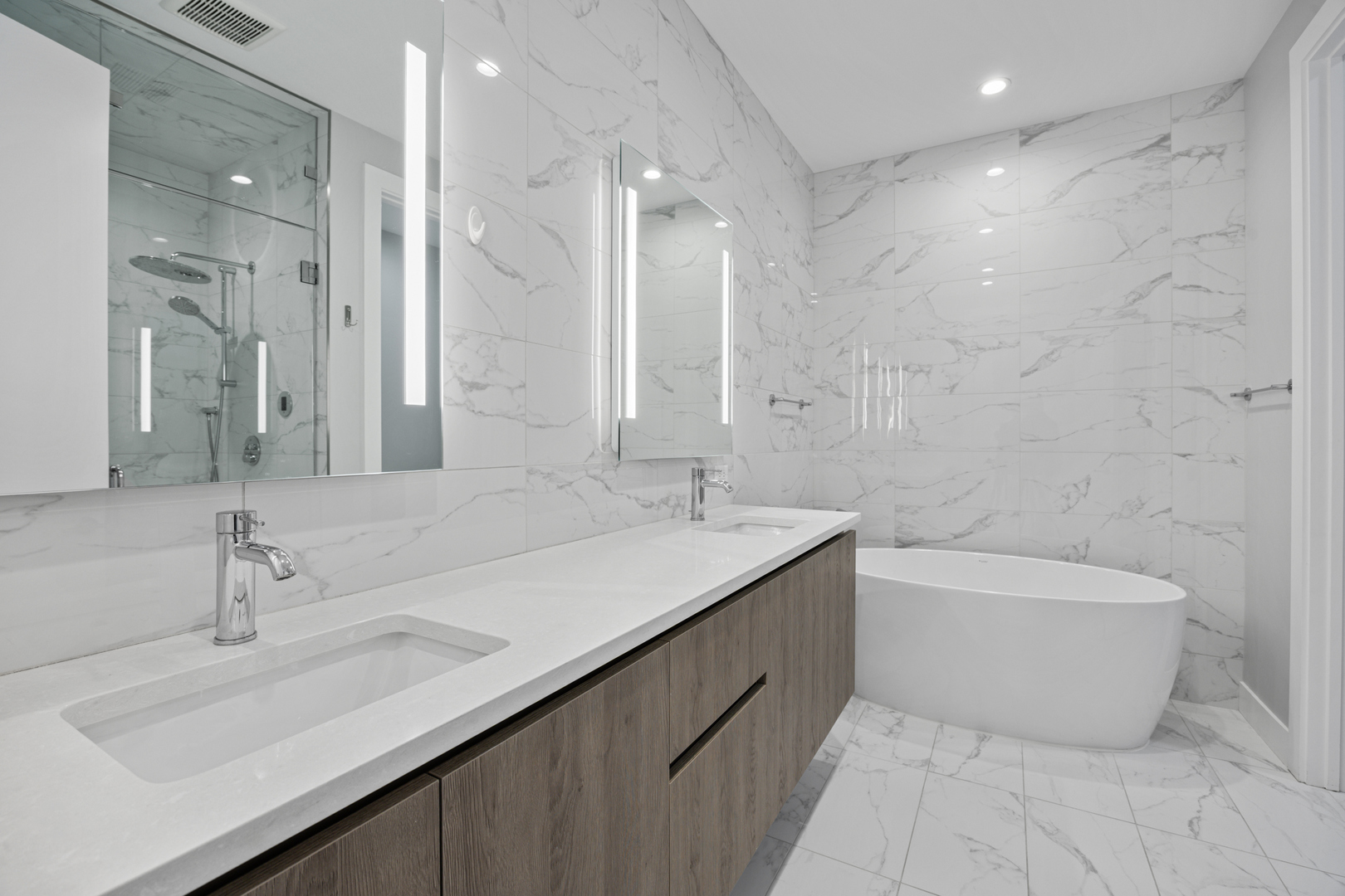 305 South Racine Avenue, Unit PHD Chicago, IL 60607 - Photo 26 of 49 a bathroom with a double vanity sink large mirror and a bathtub