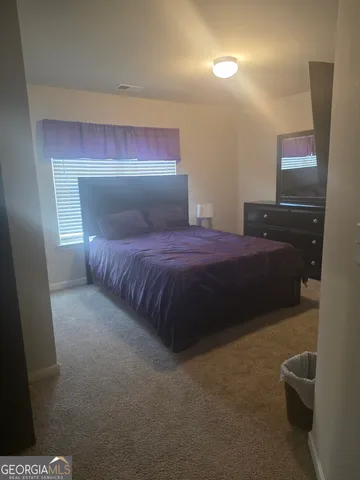 a bedroom with a bed and a potted plant