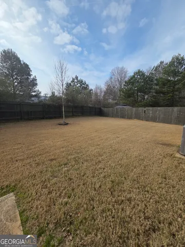 a view of a field with trees in the background