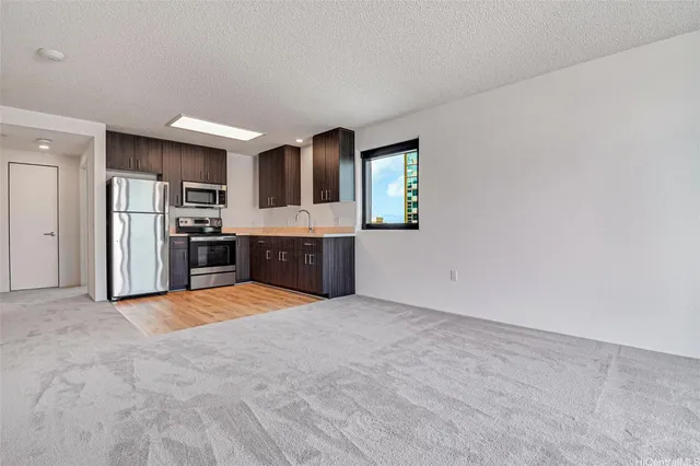a large kitchen with stainless steel appliances a refrigerator and a stove top oven
