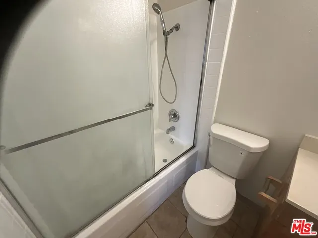 a white toilet sitting next to a shower