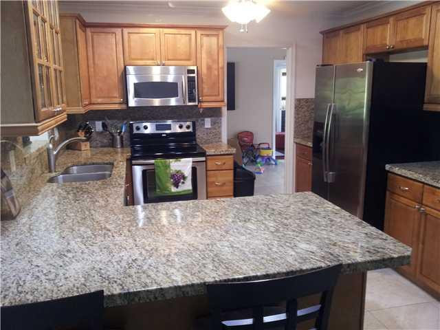 417 Apache Lane Boca Raton, FL 33487 - Photo 11 of 13 a kitchen with stainless steel appliances granite countertop a sink stove and refrigerator