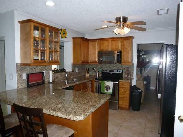417 Apache Lane Boca Raton, FL 33487 - Photo 2 of 13 a kitchen with a refrigerator and a sink