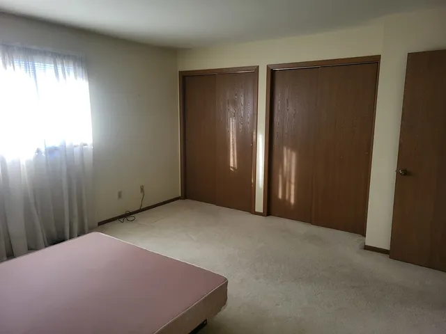 an empty room with windows and closet