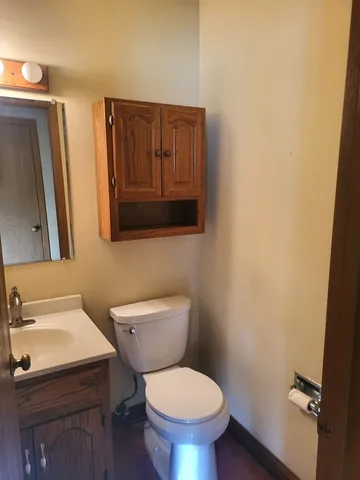 a bathroom with a toilet a sink and a mirror