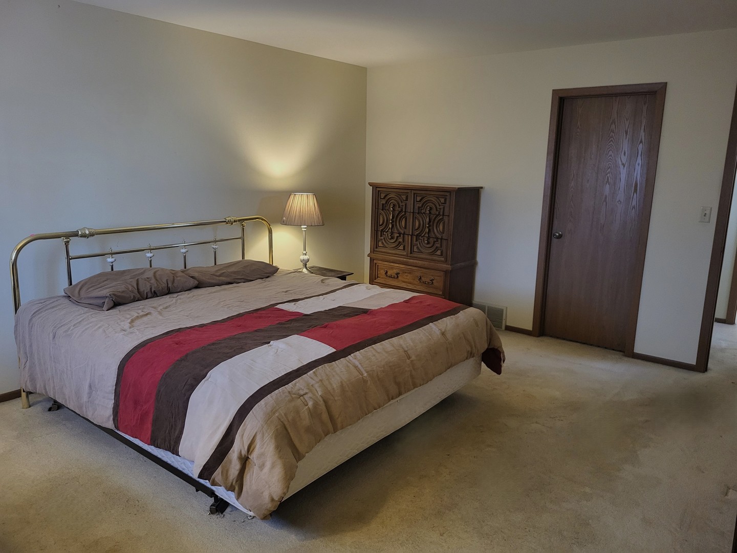 434 East Exchange Street, Unit 2 Sycamore, IL 60178 - Photo 8 of 15 a spacious bedroom with a bed and a lamp