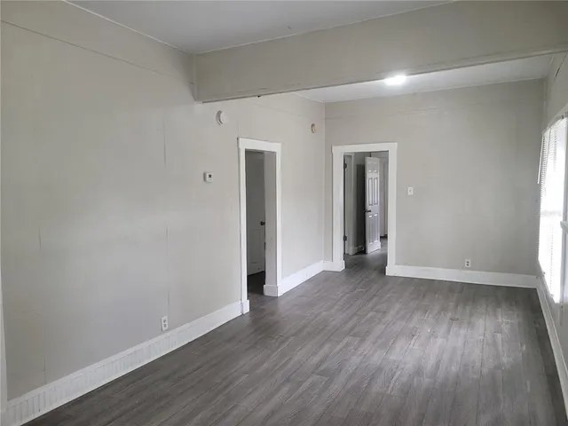 an empty room with wooden floor and closet
