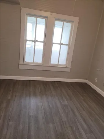 a view of wooden floor and windows in a room