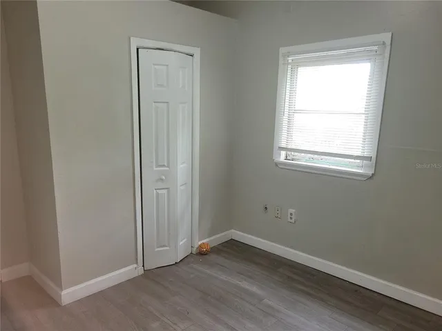 an empty room with wooden floor and a window