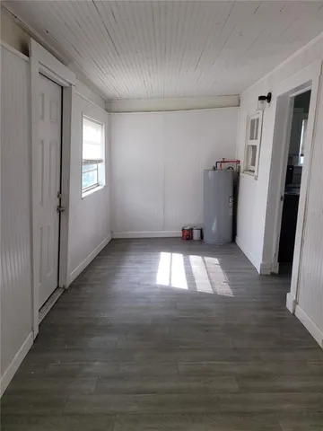 a view of empty room with wooden floor and window