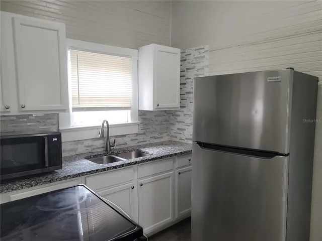 a kitchen with a refrigerator and a sink