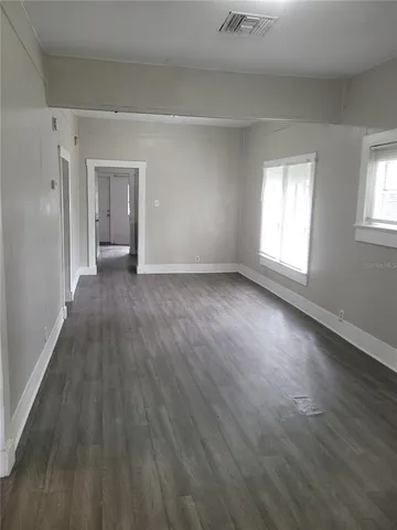 a view of a room with wooden floor and windows