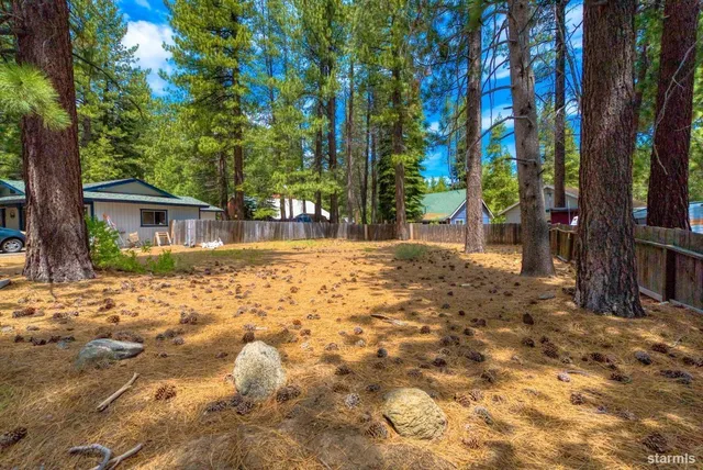a backyard of a house with large trees and outdoor seating