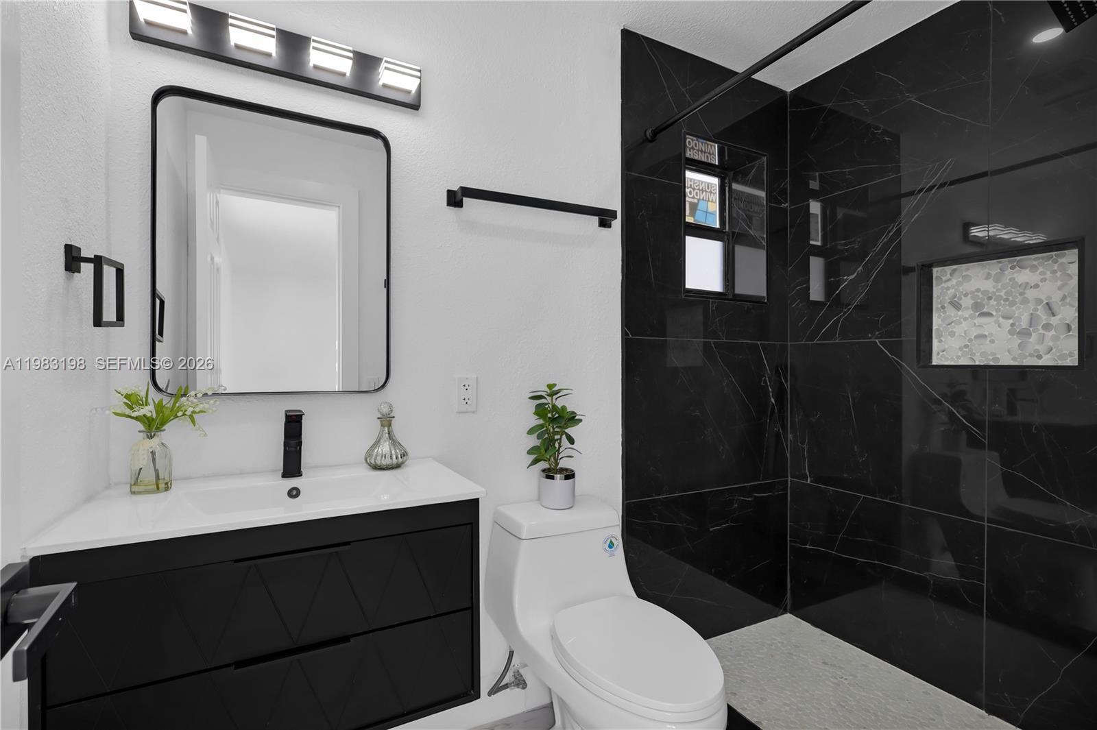 7501 Raleigh Street Hollywood, FL 33024 - Photo 6 of 21 a bathroom with a sink a toilet a shower and mirror