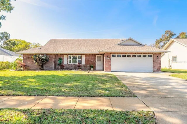 a front view of a house with a garden and yard