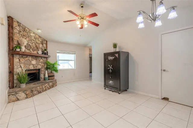 an empty room with fireplace and fan