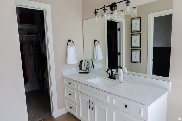 1204 North 3020th Street West Provo, UT 84601 - Photo 29 of 35 White vanity with shaker-style cabinetry, an integrated rectangular sink, and a stone-finish countertop