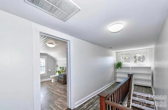 a view of a hallway and bedroom with wooden floor