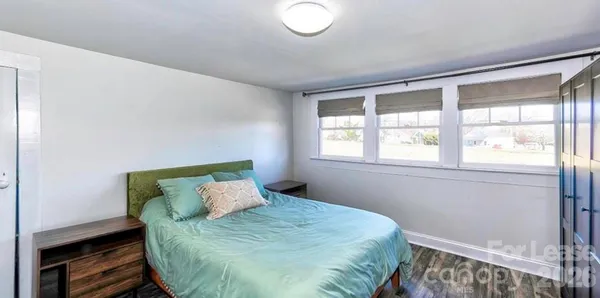 a bed sitting in a bedroom next to a window