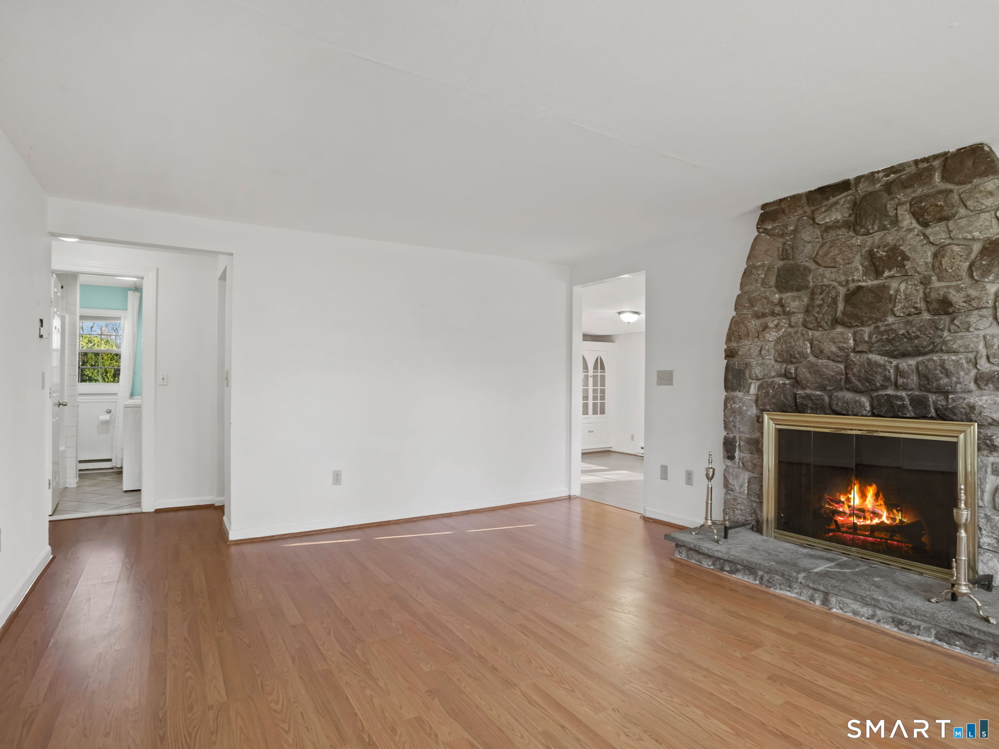 21 Richdale Drive, Unit C Wilton, CT 06897 - Photo 7 of 10 a view of an empty room with wooden floor fireplace and a window