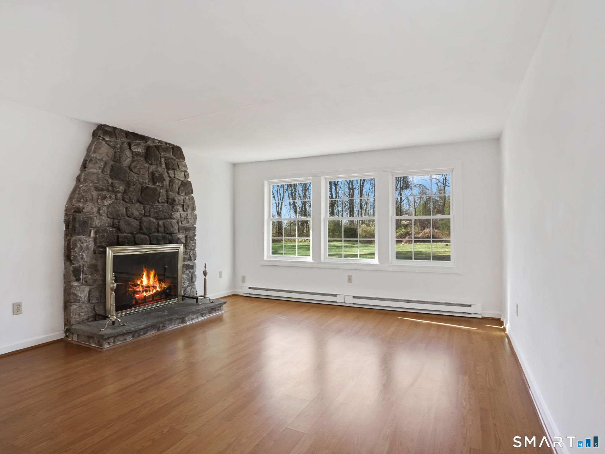 21 Richdale Drive, Unit C Wilton, CT 06897 - Photo 8 of 10 an empty room with wooden floor fire place and windows