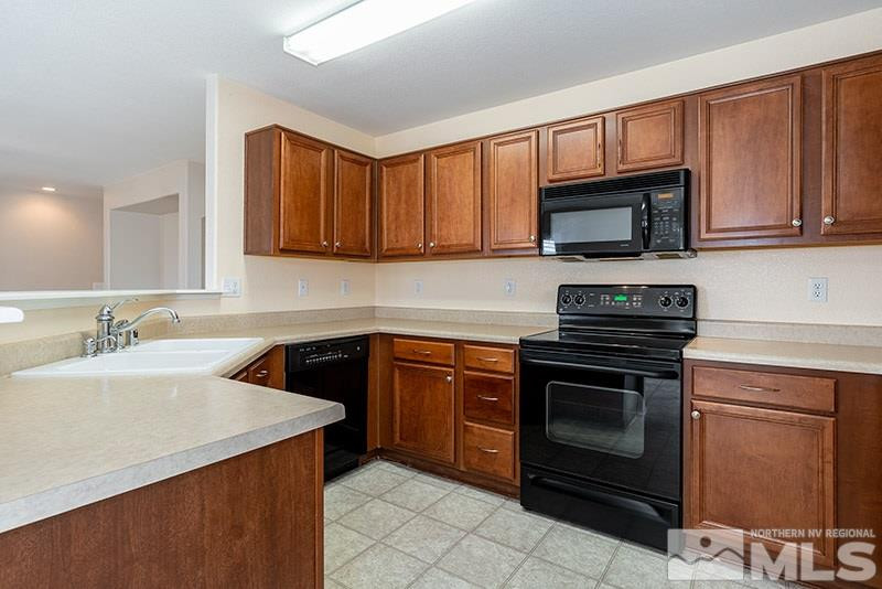 7650 Bichon Street Reno, NV 89506 - Photo 5 of 15 a kitchen with granite countertop a sink stove and microwave