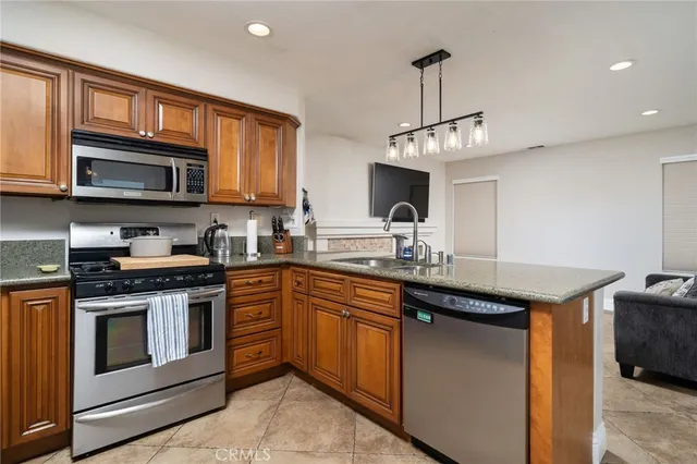 a kitchen with stainless steel appliances granite countertop a stove sink and microwave
