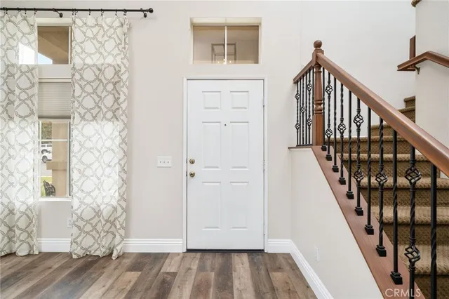 a view of a hallway with wooden floor and entryway