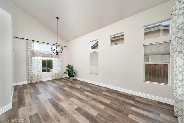 a view of an empty room with a window and chandelier