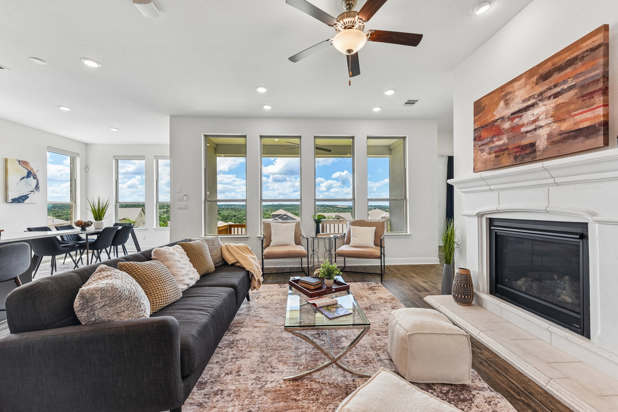 19113 Freeman Circle Austin, TX 78738 - Photo 11 of 37 A well-lit living space, featuring high ceilings, a fireplace, and a dining area, offers panoramic views.
