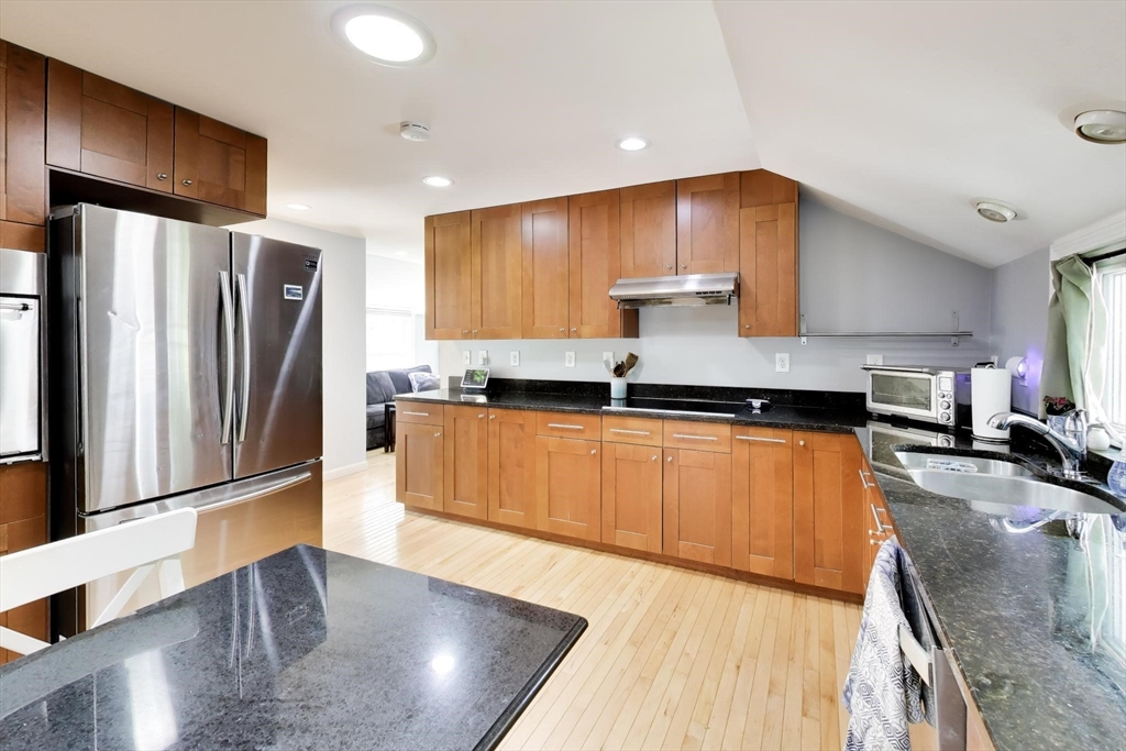 22 Douglas Road Ashland, MA 01721 - Photo 11 of 24 a kitchen with stainless steel appliances granite countertop a refrigerator a stove and a sink with wooden floors