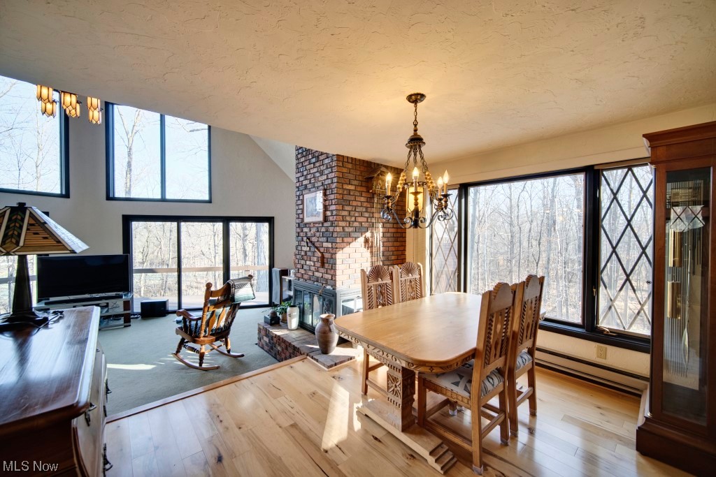 41974 Butternut Ridge Road Elyria, OH 44035 - Photo 18 of 50 Dining Area/ hardwood / wood-style flooring, a brick fireplace, a notable chandelier, and brick fireplace
