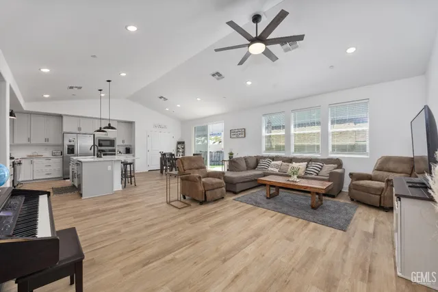 a living room with furniture kitchen view and a large window