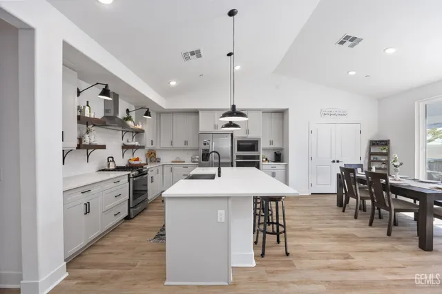 a large kitchen with kitchen island a sink table and chairs