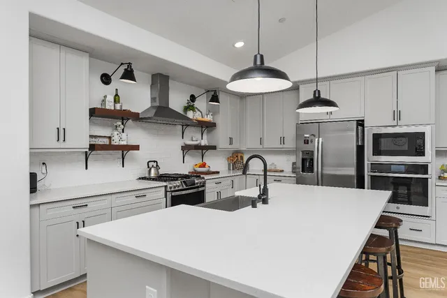 a kitchen with stainless steel appliances a table a stove a refrigerator and cabinets