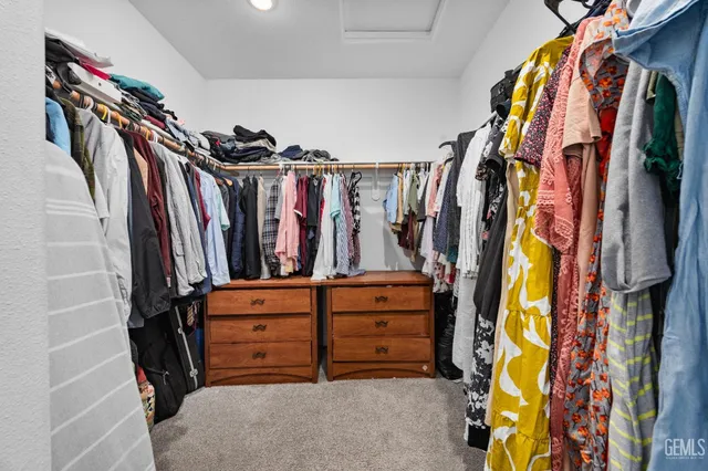 a view of walk in closet with clothes