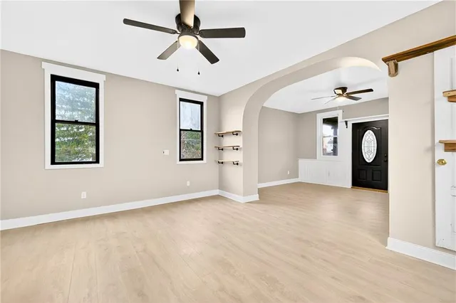 an empty room with windows and fan