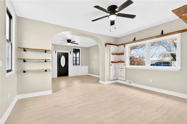 a view of empty room with a ceiling fan and window