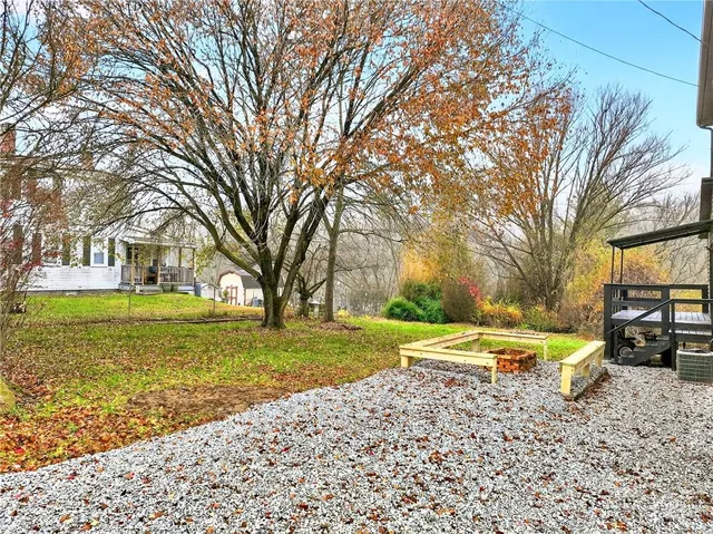 a view of a house with backyard and trees