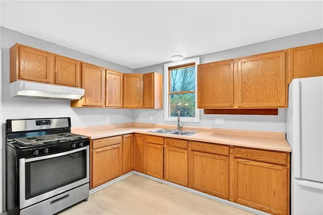 a kitchen with granite countertop stainless steel appliances a sink stove and cabinets