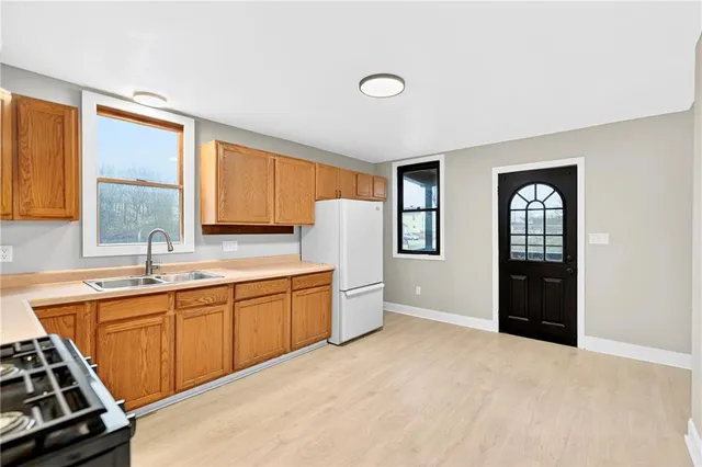 a large kitchen with stainless steel appliances granite countertop a sink stove and refrigerator