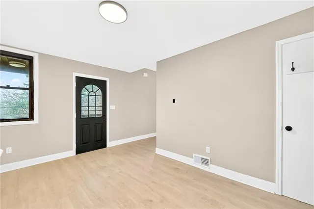 an empty room with windows and closet