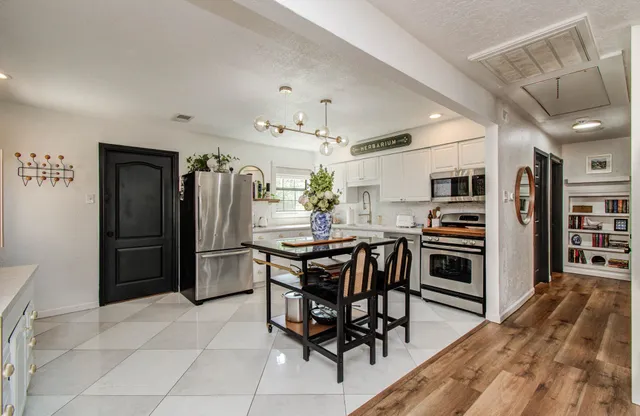 a kitchen with stainless steel appliances kitchen island granite countertop a refrigerator and a stove top oven