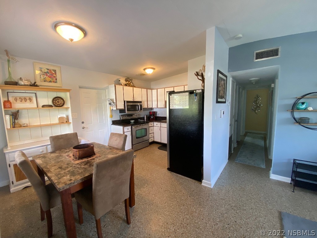 229 Robinson Road New Smyrna Beach, FL 32169 - Photo 4 of 23 a kitchen with granite countertop kitchen island stainless steel appliances a refrigerator a sink a stove a table and chairs