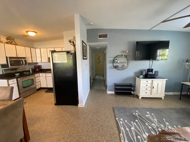 a kitchen with stainless steel appliances granite countertop a refrigerator and a stove