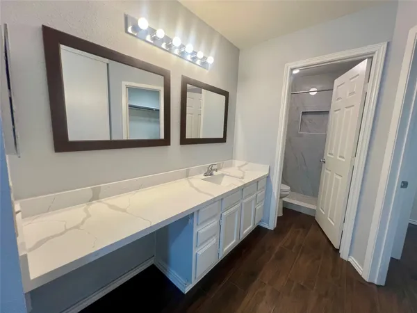 a bathroom with a sink a large mirror and a bathtub