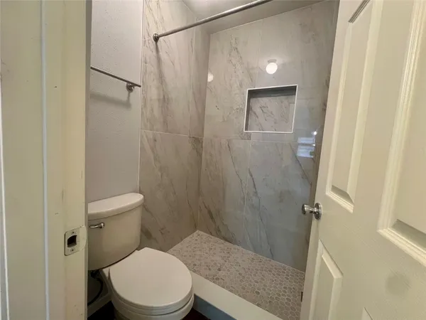 a bathroom with a toilet and a shower