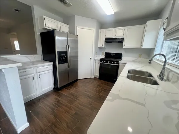 a kitchen with a refrigerator stove and wooden cabinets