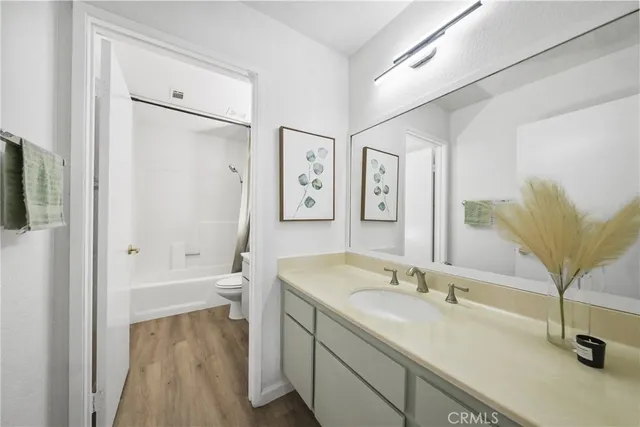 a bathroom with a granite countertop sink a mirror and a shower