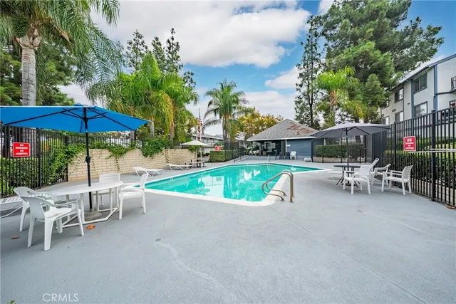 a view of a chairs and table under an umbrella in backyard